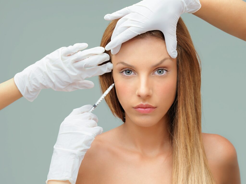 young woman with doctor hands injecting botox